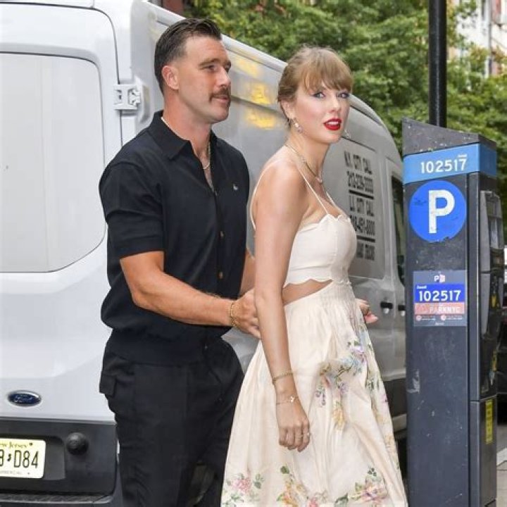 Taylor and Joe at an awards ceremony, sat looking over to the left while leaning into each other